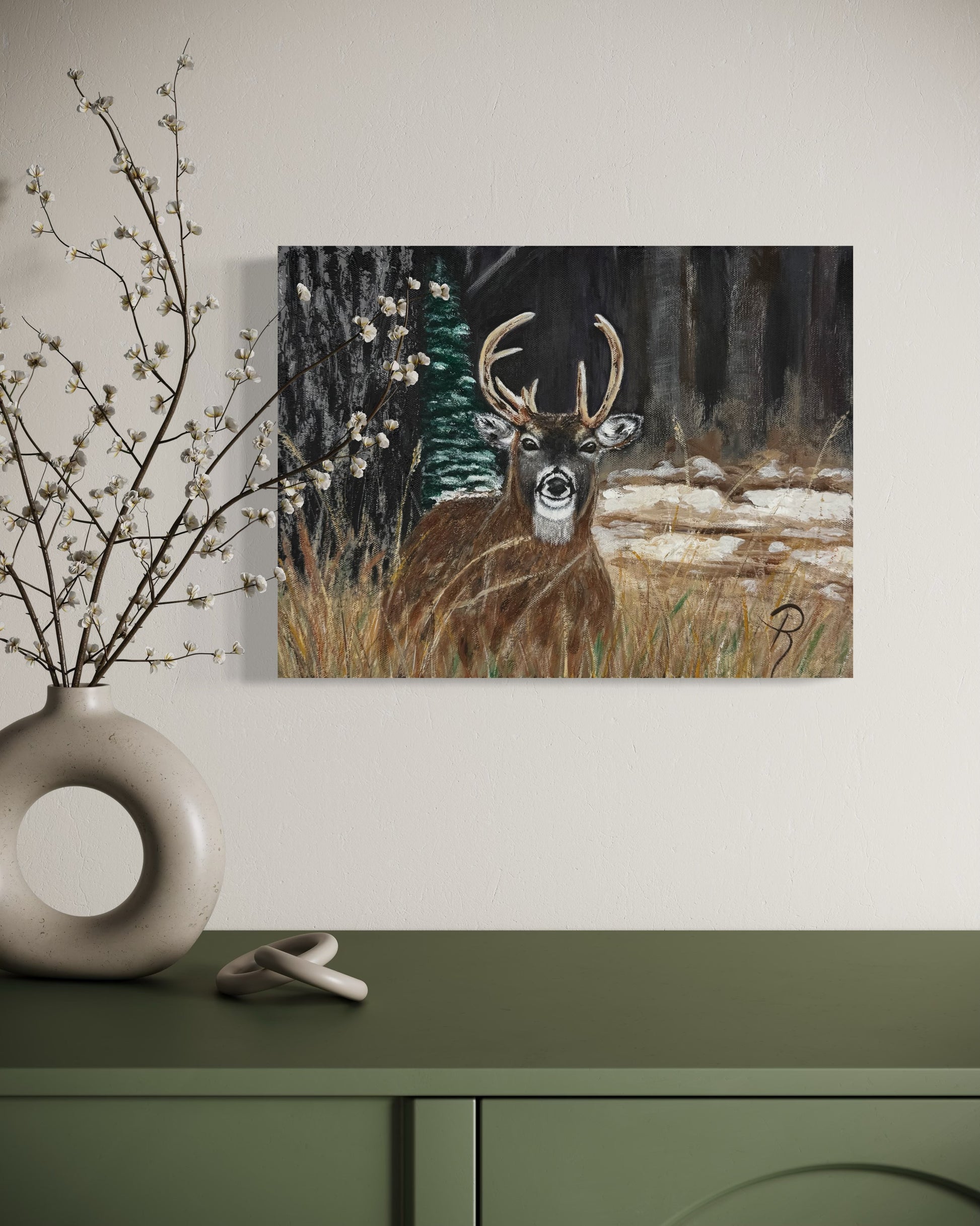Framed painting of a deer in a forest scene on a wall above a green cabinet with decorative elements.