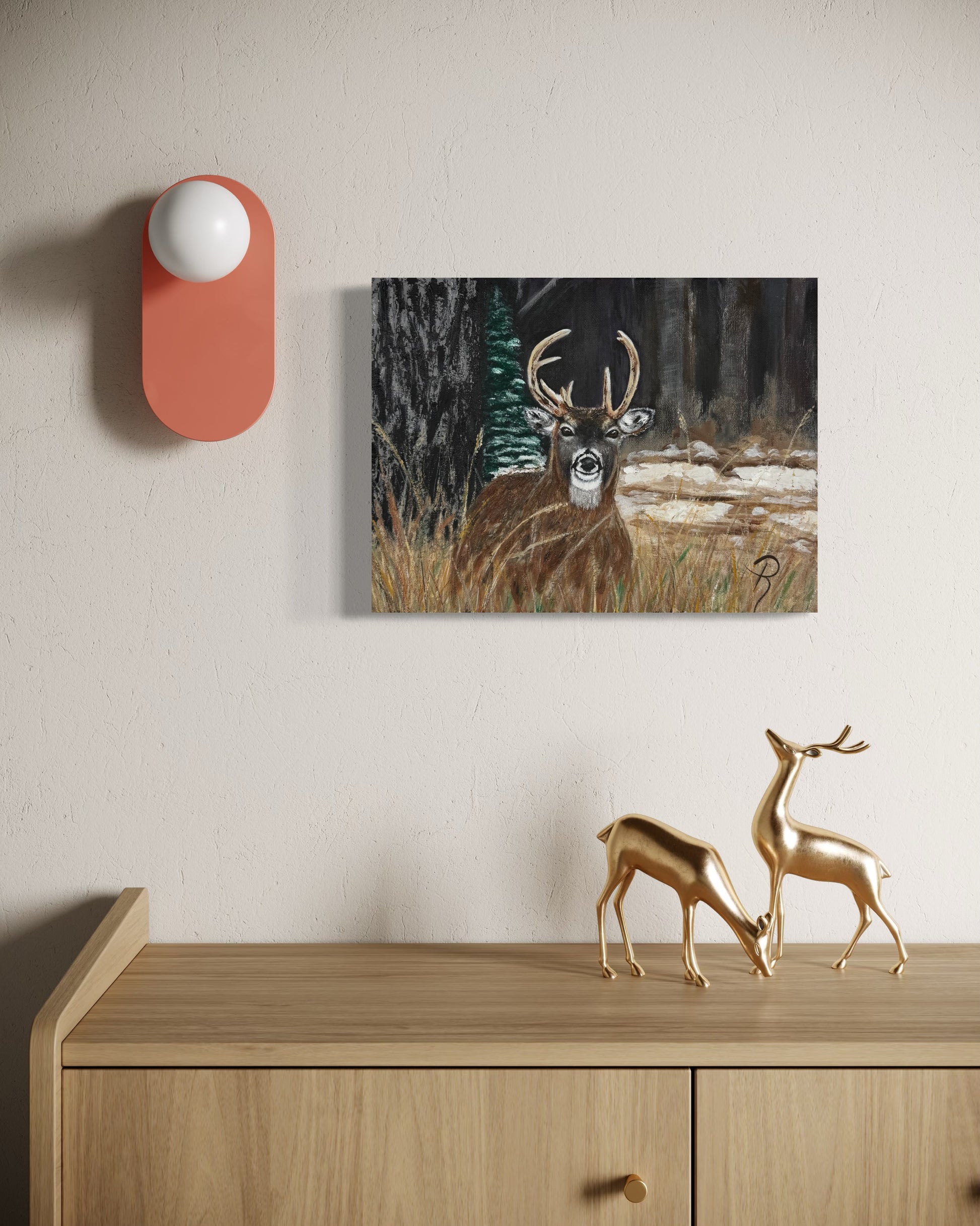 Decorative scene with a painting of a deer, a pink wall light, and gold deer figurines on a wooden surface.